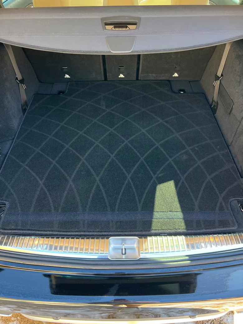 Spotless SUV cargo area with vacuumed carpet and polished chrome sill after an interior detail